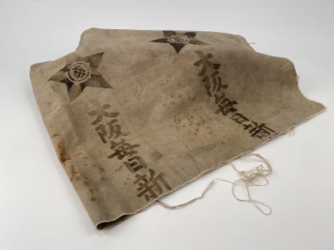 A worn drop cloth with Japanese characters printed on it. 