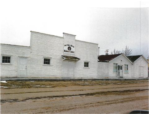 A photo of a white building with the words 'Picture Butte Buddhist Church' on a sign above the door.